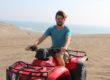 Young man on an ATV at the beach.